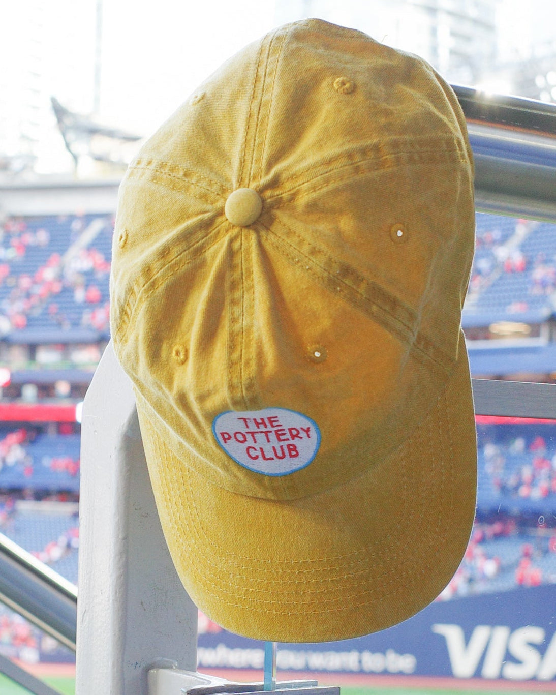 Yellow cap with a sticker on a stand at a sports stadium